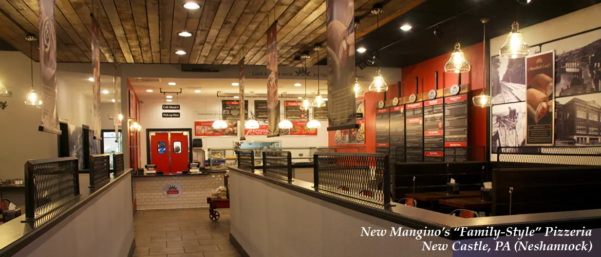 Interior view of New Mangino's "Family-Style" Pizzeria in New Castle, PA, featuring a wooden ceiling, hanging lights, red and white decor, and menu boards above the counter.