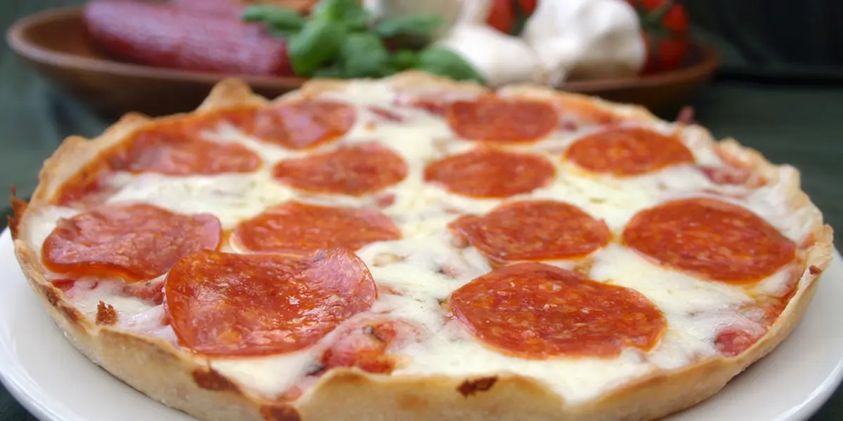 A pepperoni pizza sitting on top of a table.